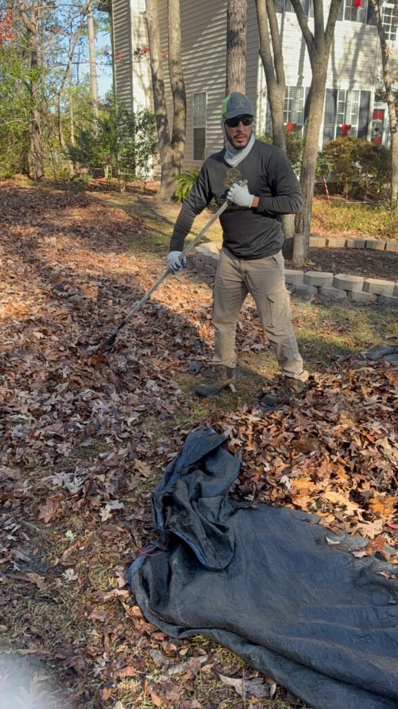 Fresh Cut Landscaping employee cleaning up leaves out ouf client's yard